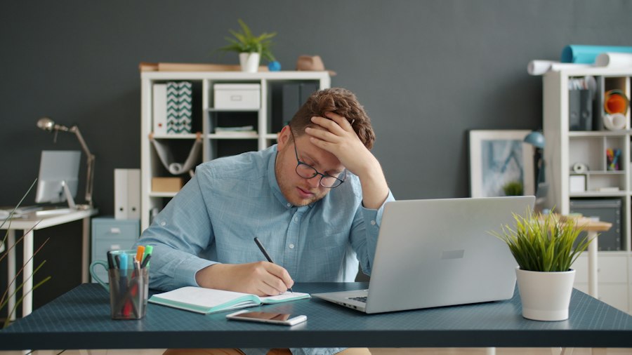 A professional at a laptop looking worried about their career