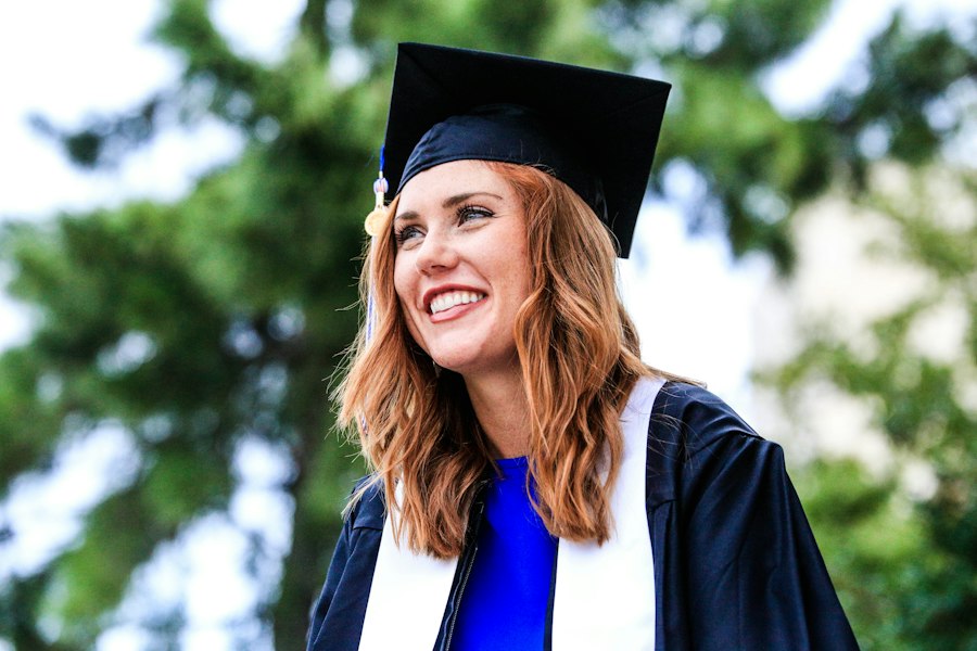 A smiling graduate in a cap and gown